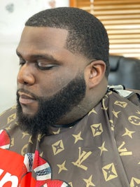 a man with a beard sitting in a barber chair