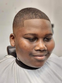 a young boy is getting a haircut in a barber shop